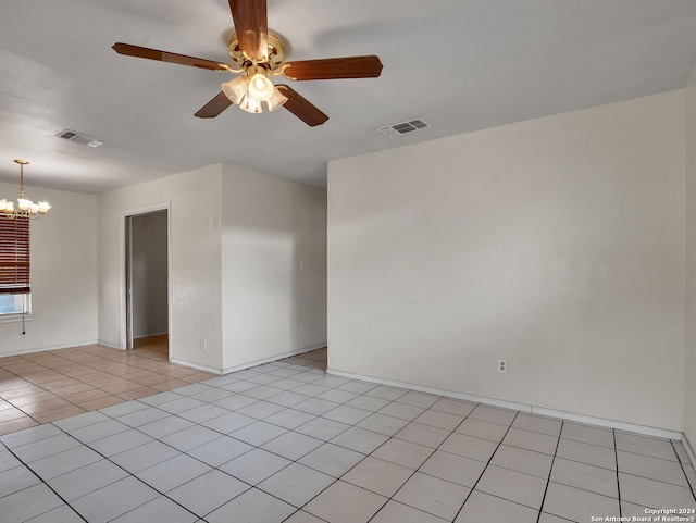 tiled empty room featuring ceiling fan with notable chandelier