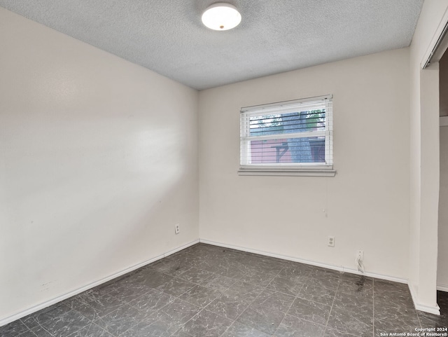 spare room with a textured ceiling