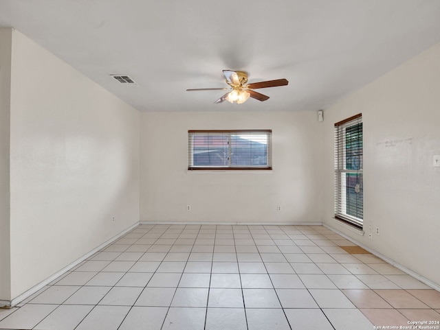 tiled empty room featuring ceiling fan