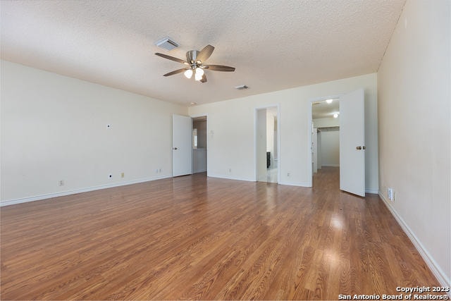 empty room featuring hardwood / wood-style floors, ceiling fan, and a textured ceiling