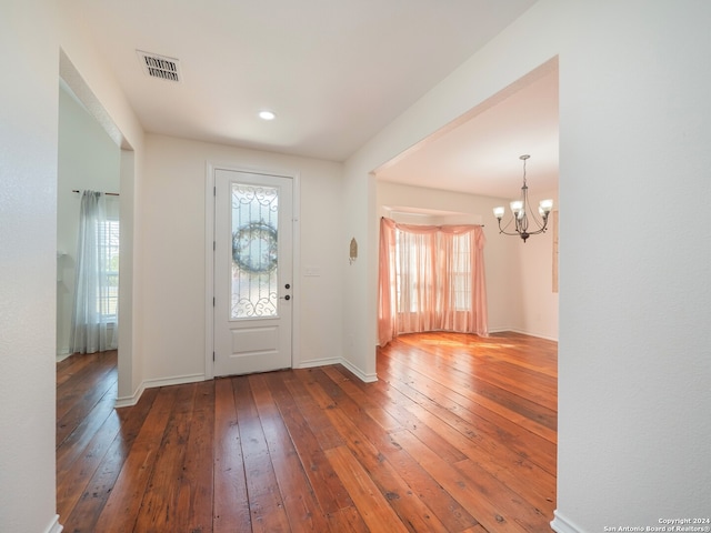 entryway with hardwood / wood-style flooring and a chandelier