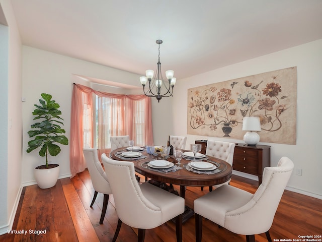 dining area featuring wood-type flooring and a chandelier