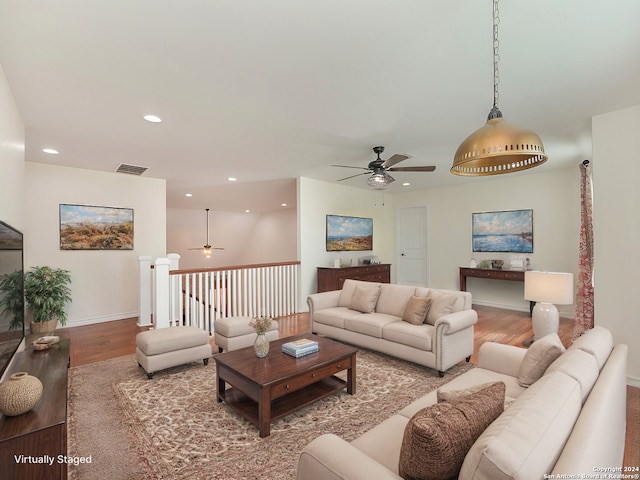 living room featuring hardwood / wood-style floors and ceiling fan