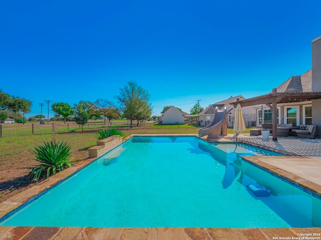 view of pool featuring an outdoor living space, a water slide, a yard, a patio area, and a pergola