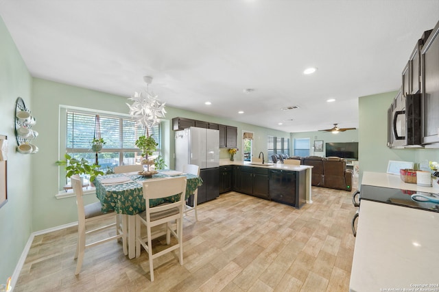 kitchen with light hardwood / wood-style floors, sink, kitchen peninsula, hanging light fixtures, and white refrigerator