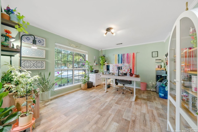 home office with light hardwood / wood-style floors and crown molding