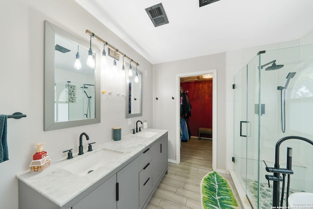 bathroom with vanity, an enclosed shower, and wood-type flooring