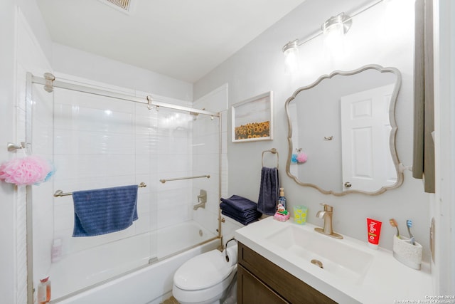 full bathroom featuring toilet, combined bath / shower with glass door, and vanity