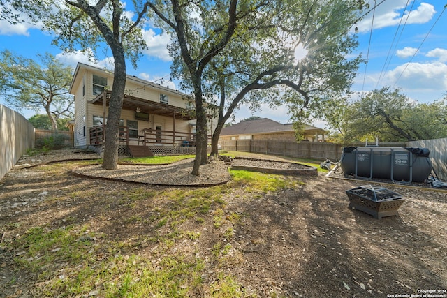 view of yard featuring an outdoor fire pit and a deck