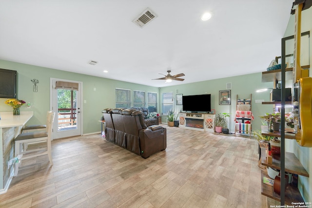 living room with light hardwood / wood-style floors and ceiling fan