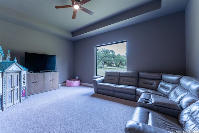 carpeted living room featuring ceiling fan and a tray ceiling