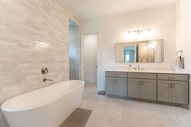 bathroom featuring vanity, tile patterned floors, and a tub