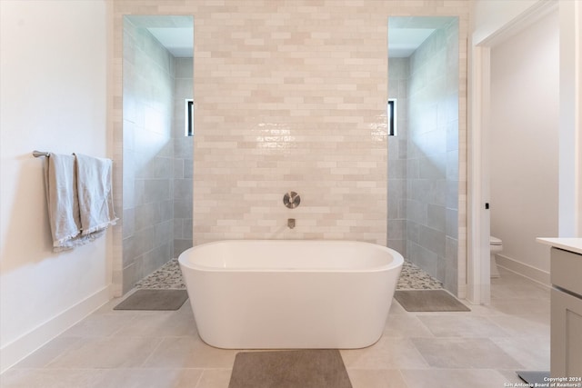 full bathroom featuring toilet, separate shower and tub, tile patterned floors, tile walls, and vanity