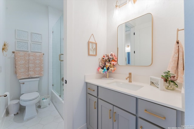 full bathroom featuring toilet, vanity, bath / shower combo with glass door, and tile patterned floors