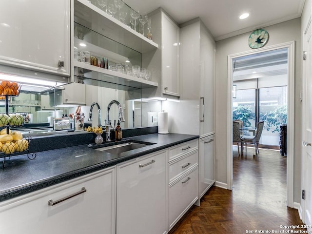 kitchen featuring sink, white cabinetry, and dark parquet floors