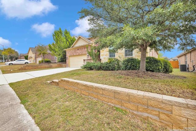 view of property hidden behind natural elements with a garage, central air condition unit, and a front yard