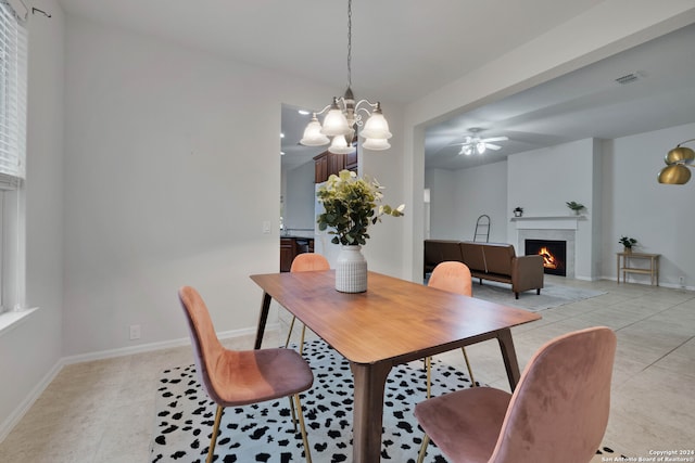 dining area featuring a fireplace, ceiling fan with notable chandelier, and light tile patterned floors