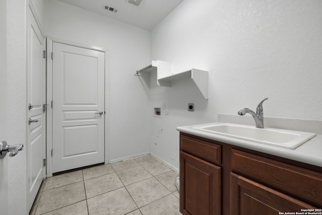 washroom with hookup for an electric dryer, cabinets, sink, light tile patterned floors, and hookup for a washing machine