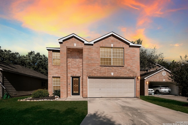 traditional-style house featuring driveway, brick siding, an attached garage, and a front yard