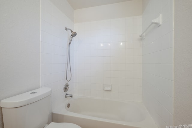 bathroom with toilet and tiled shower / bath combo