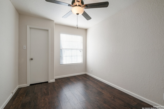 spare room with dark hardwood / wood-style floors and ceiling fan