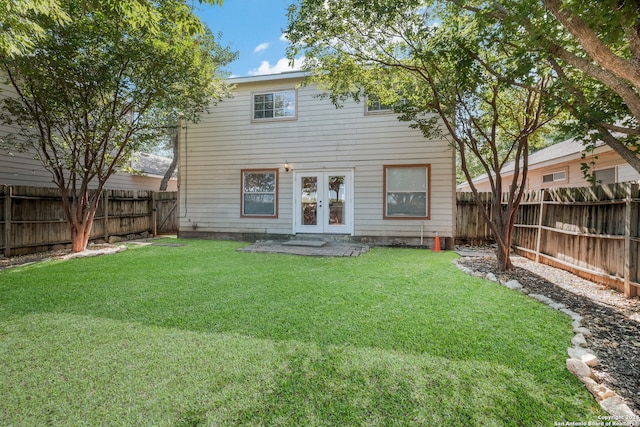 rear view of house with a lawn and french doors