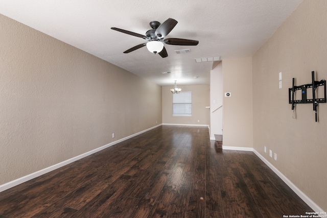 unfurnished room with dark wood-type flooring, visible vents, baseboards, and ceiling fan with notable chandelier