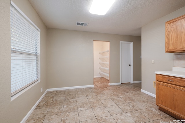 kitchen with a textured ceiling and light tile patterned flooring