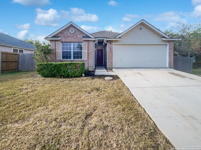 single story home with a garage and a front lawn