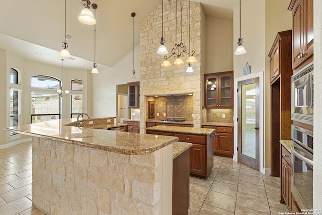 kitchen featuring pendant lighting, a spacious island, stainless steel appliances, and high vaulted ceiling