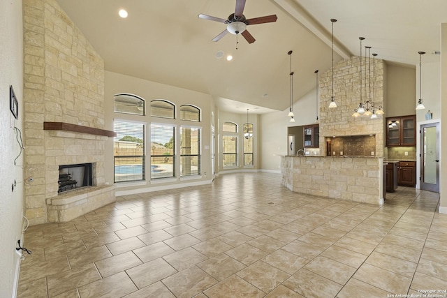 100 Vintage Ranch Cir, La Vernia, TX 78121 - unfurnished living room featuring high vaulted ceiling, a ceiling fan, a fireplace, beamed ceiling, and baseboards