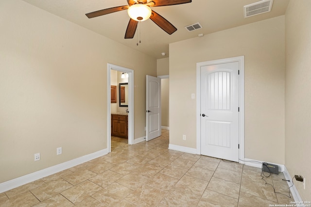 unfurnished bedroom featuring ceiling fan and ensuite bath