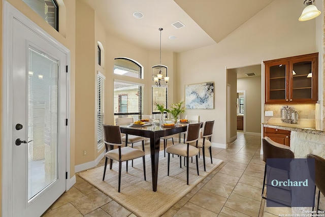 100 Vintage Ranch Cir, La Vernia, TX 78121 - dining space featuring light tile patterned floors, a high ceiling, a chandelier, and baseboards
