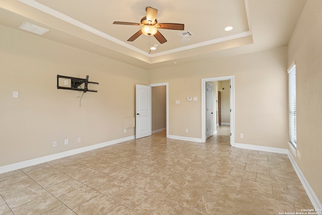 unfurnished room with ceiling fan, a raised ceiling, and crown molding