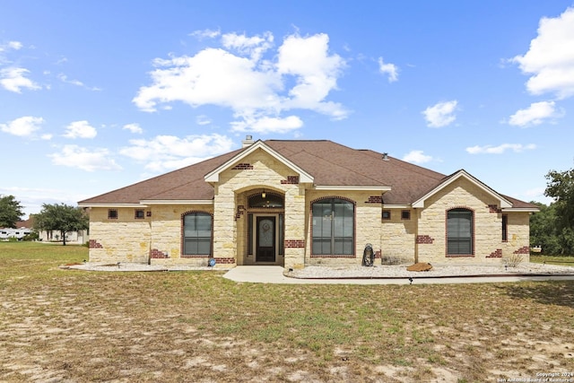 100 Vintage Ranch Cir, La Vernia, TX 78121 - french country inspired facade with stone siding, a front lawn, roof with shingles, and a chimney