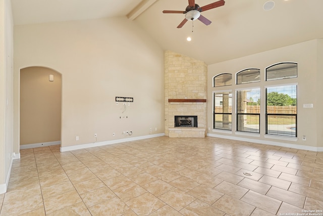 unfurnished living room with beamed ceiling, high vaulted ceiling, ceiling fan, and a fireplace