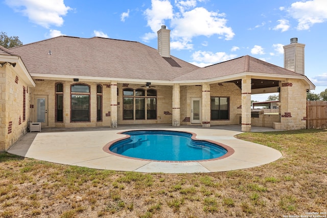 view of swimming pool featuring ceiling fan, a patio area, and a lawn