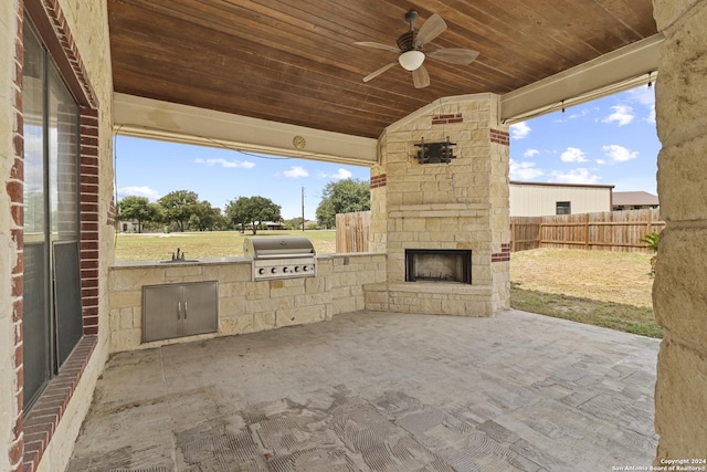 100 Vintage Ranch Cir, La Vernia, TX 78121 - view of patio / terrace featuring an outdoor stone fireplace, a grill, exterior kitchen, a ceiling fan, and fence