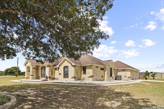 100 Vintage Ranch Cir, La Vernia, TX 78121 - single story home featuring stone siding, a front lawn, and central AC unit