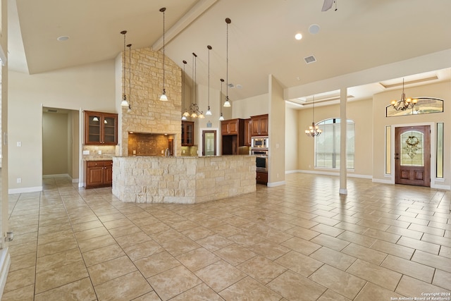 kitchen featuring beam ceiling, a large island, stainless steel appliances, and decorative light fixtures