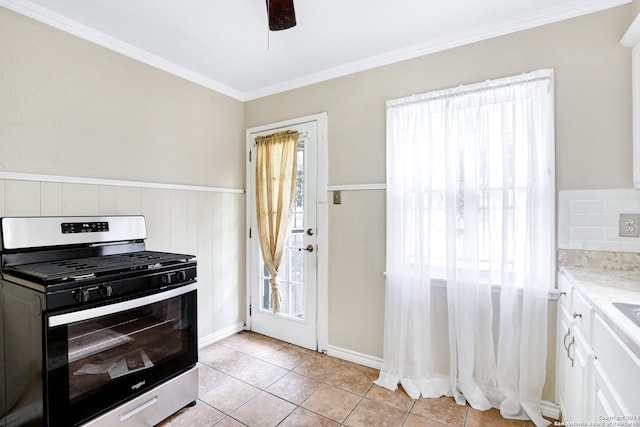 kitchen featuring stainless steel range with gas cooktop, plenty of natural light, white cabinetry, and ornamental molding