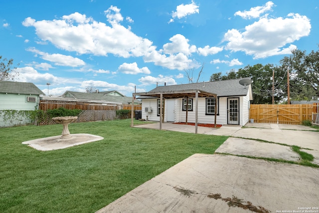 back of house with a patio and a lawn