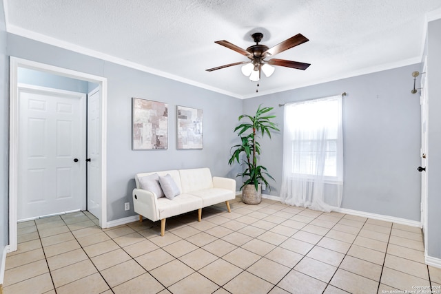 living area with ceiling fan, a textured ceiling, light tile patterned floors, and ornamental molding