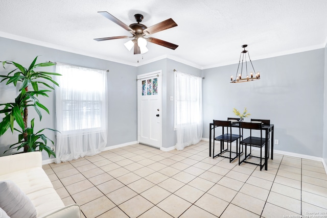 tiled dining space with ceiling fan with notable chandelier, a healthy amount of sunlight, and crown molding