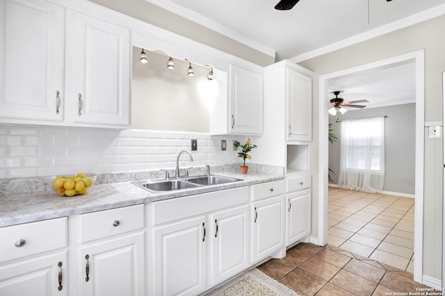 kitchen featuring sink, ceiling fan, crown molding, backsplash, and white cabinetry