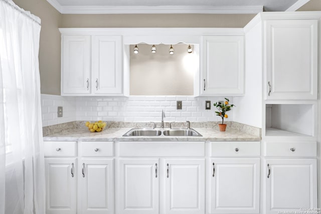 kitchen featuring white cabinets, sink, decorative backsplash, and ornamental molding