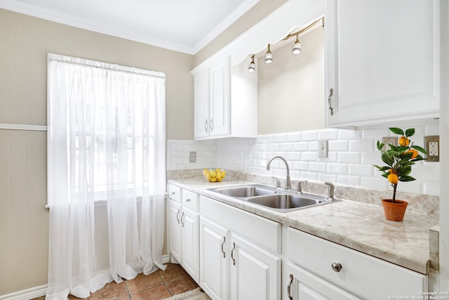 kitchen featuring light tile patterned flooring, ornamental molding, white cabinetry, backsplash, and sink