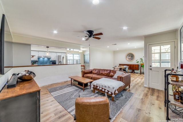 living room with light hardwood / wood-style floors and ceiling fan