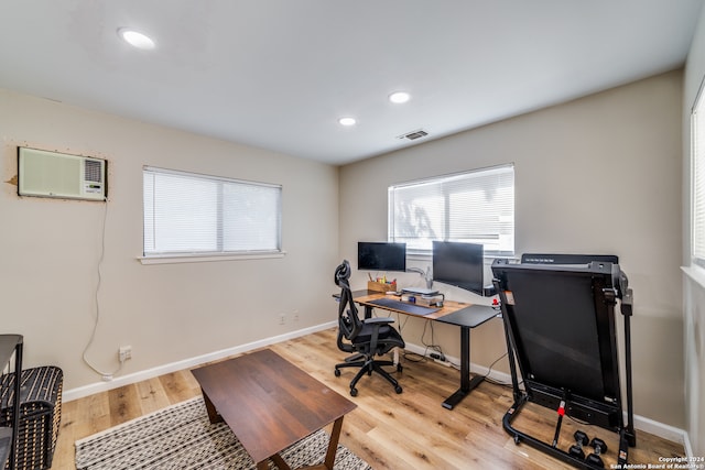 home office featuring a wall unit AC and light wood-type flooring