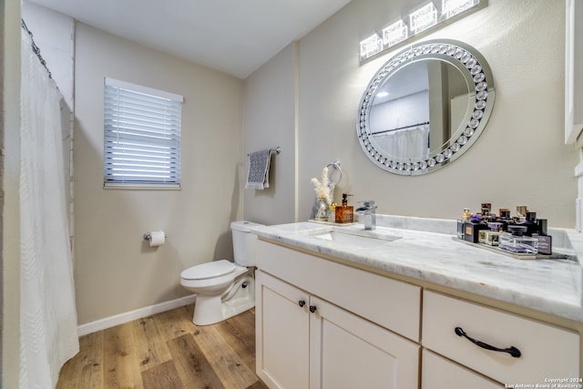 bathroom with wood-type flooring, vanity, and toilet